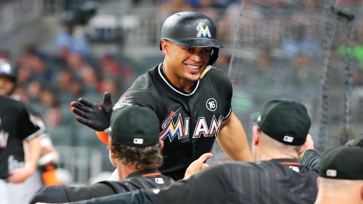 Miami Marlins' Giancarlo Stanton (27) is greeted at the dugout after hitting a two-run home run during the sixth inning of the team's baseball game against the Atlanta Braves on Friday, Aug. 4, 2017, in Atlanta. It was Stanton's second homer of the game.