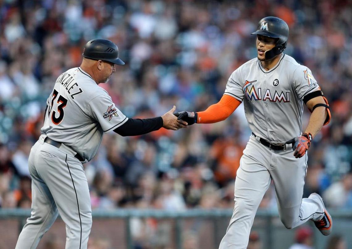 Miami Marlins’ Giancarlo Stanton, right, is congratulated by third base coach Fredi Gonzalez after hitting a two-run home run off San Francisco Giants’ Matt Moore during the first inning of a baseball game Friday, July 7, 2017, in San Francisco.