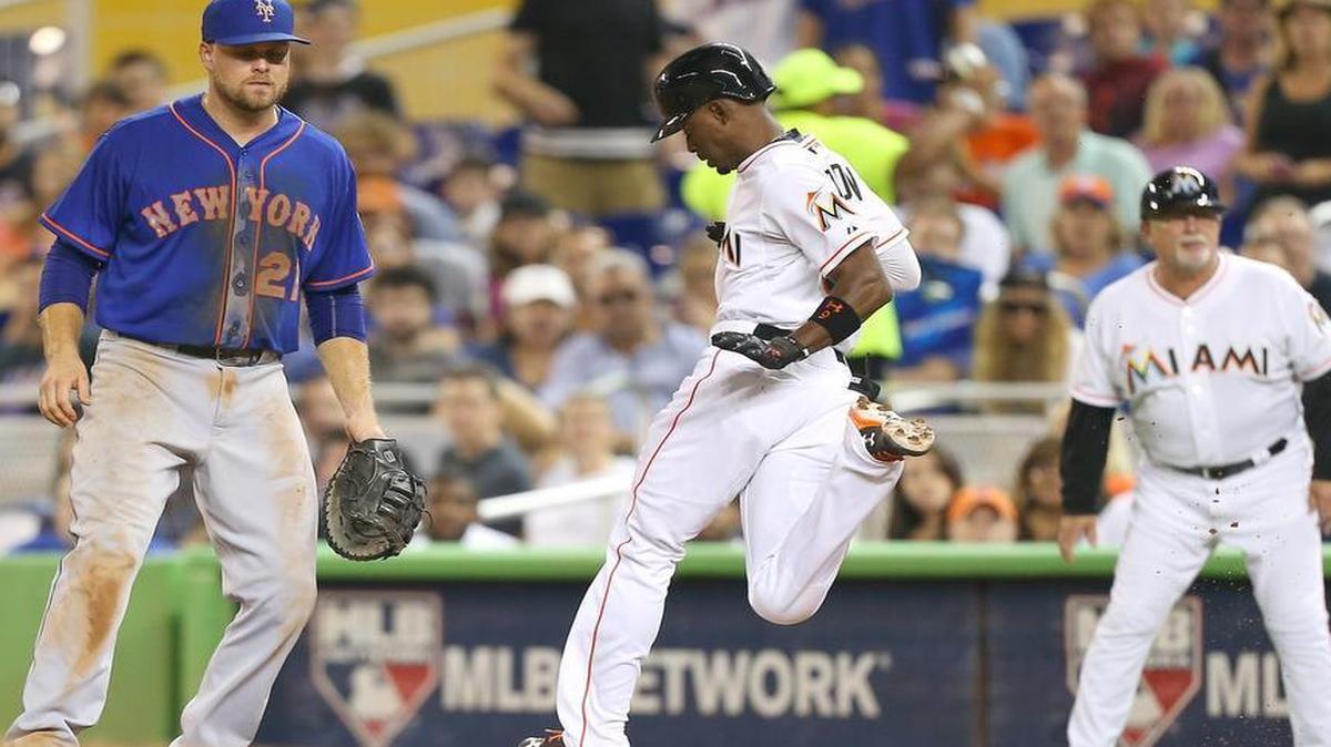 
Dee Gordon of the Miami Marlins, center, reaches safely to first base on a single in the third inning against the New York Mets on Wednesday, Aug. 5, 2015 at Marlins Park in Miami.
