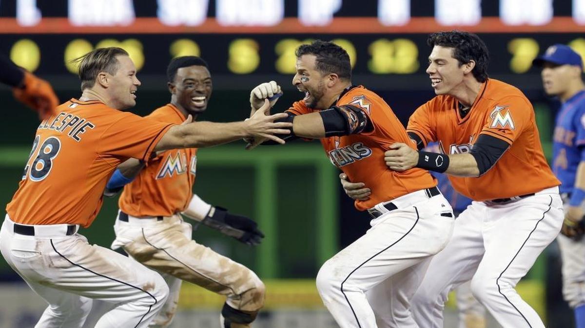
Miami Marlins' Martin Prado, second from right, is congratulated by teammates after hitting a walk-off sacrifice fly with the bases loaded against the New York Mets in the ninth inning Sunday, Sept. 6, 2015, in Miami. Marlins' J.T. Realmuto scored the game-winning run in the 4-3 victory. 
