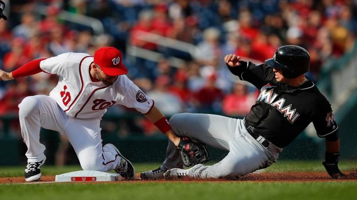 Washington Nationals' Stephen Drew (10) tags out Miami Marlins' Martin Prado (14), who was attempting to steal third during the first inning at Nationals Park, Sunday, Oct. 2, 2016, in Washington. Umpire Jeff Kellogg, left, makes the call.