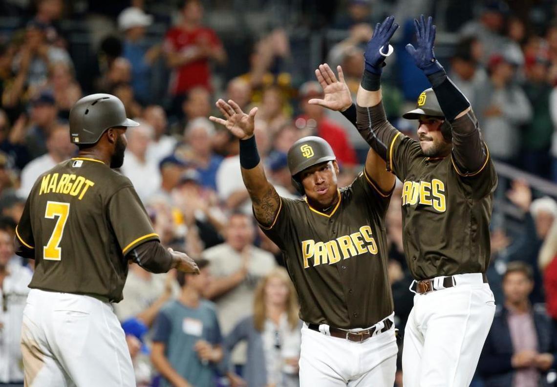 San Diego Padres catcher Austin Hedges, right, celebrates his three-run home run with teammates Manuel Margot, left, and Yangervis Solarte during the seventh inning of a baseball game against the Miami Marlins in San Diego, Fri., April 21, 2017.