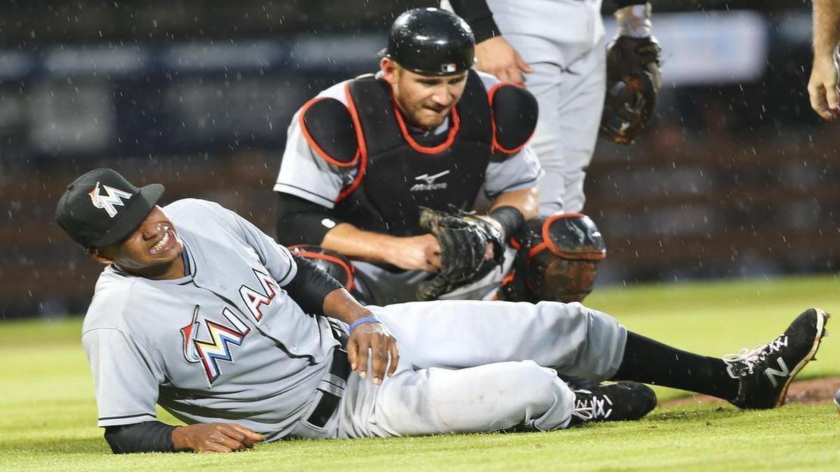 
Miami Marlins pitcher Jose Urena (62) reacts in pain after being injured in the second inning of a baseball game against the Atlanta Braves Thursday, Aug. 6, 2015, in Atlanta. Urena stayed in the game. Miami Marlins catcher Jeff Mathis (6) looks on at rear. 
