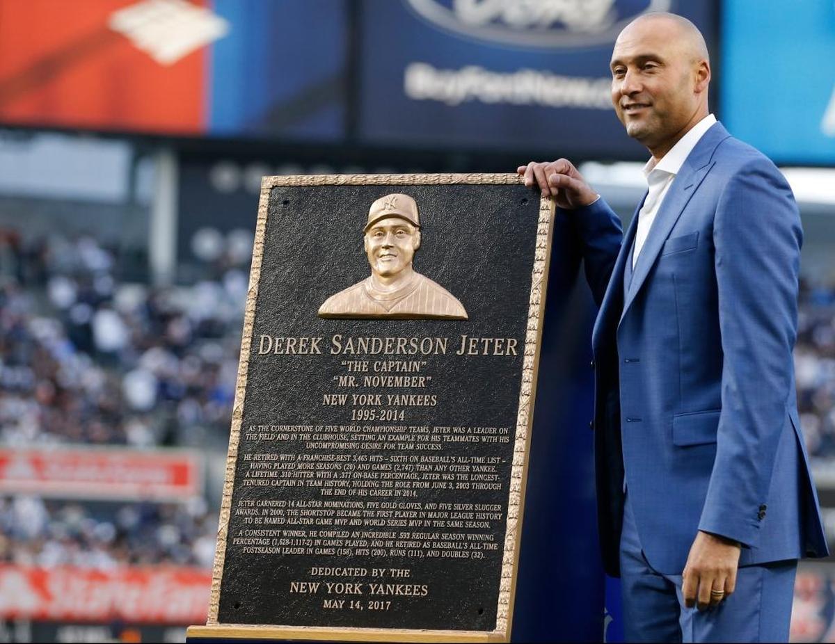 Retired New York Yankees shortstop Derek Jeter poses with a replica of the plaque that was installed in Monument Park during a pregame ceremony retiring his No. 2 at Yankee Stadium on May 14, 2017.