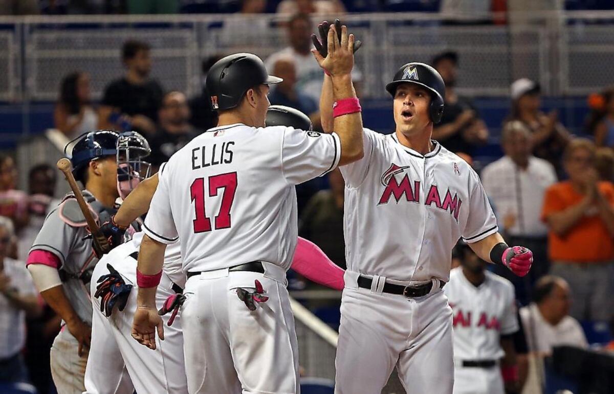 The Marlins' Tyler Moore is greeted by teammate A.J. Ellis after his 3-run home run as the Miami Marlins beat the Atlanta Braves on Sunday, May 14, 2017.