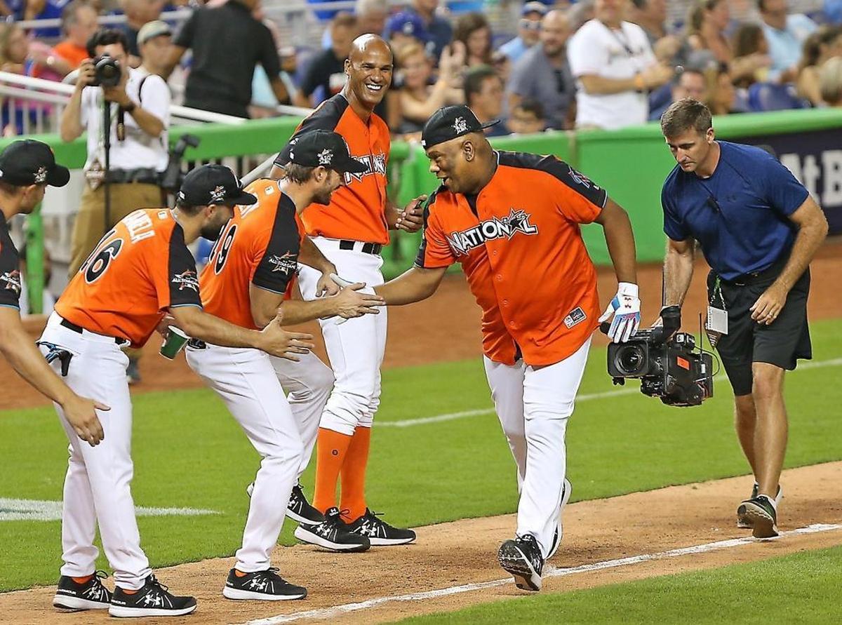 Livan Hernandez celebrates with his teammates —including former Miami Dolphin Jason Taylor — fter hitting a home run during Sunday’s celebrity softball game at Marlins Park.