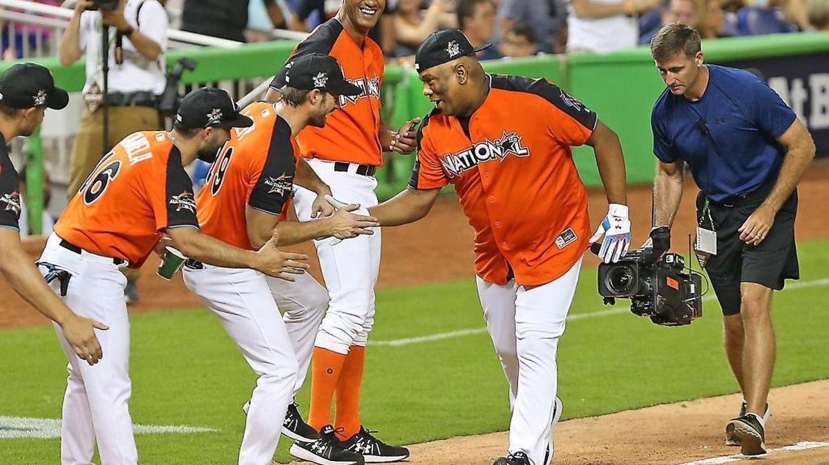 Livan Hernandez celebrates with his teammates —including former Miami Dolphin Jason Taylor — fter hitting a home run during Sunday’s celebrity softball game at Marlins Park.