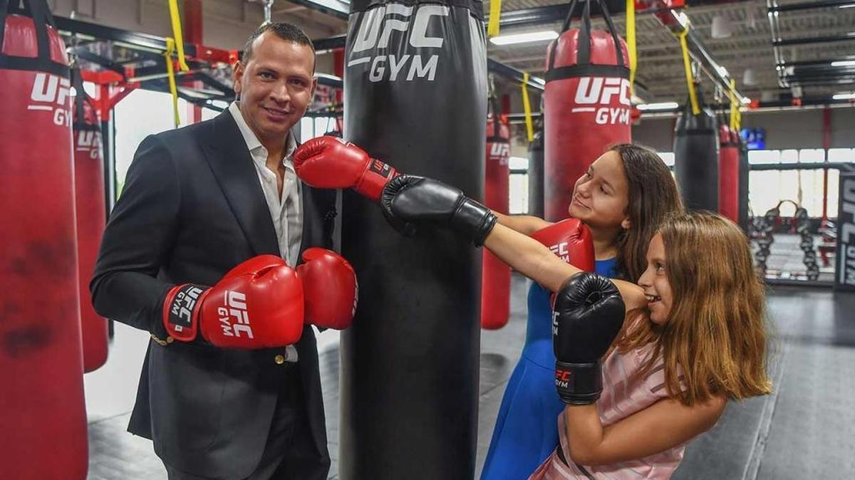 Former New York Yankees slugger Alex Rodriguez takes some playful jabs from daughters Natasha (left) and Ella (right) at the opening of his UFC GYM in Kendall last Thursday.