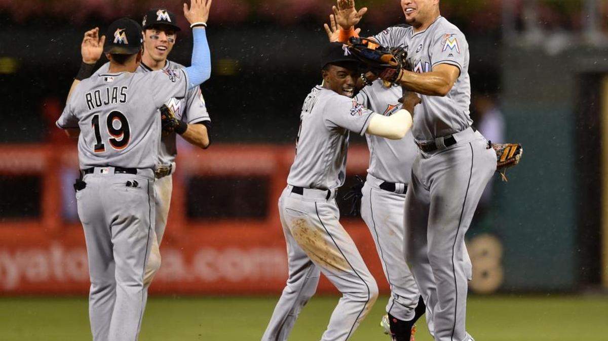 Giancarlo Stanton, right, celebrates with teammates Dee Gordon, Miguel Rojas and Christian Yelich following Tuesday’s sweep of a doubleheaders against the host Philadelphia Phillies.