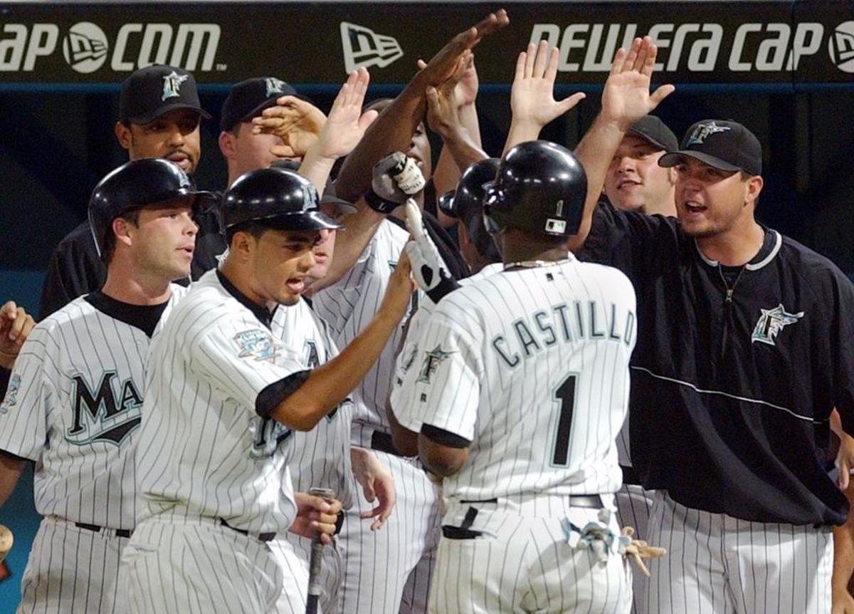 Florida’s Luis Castillo is greeted by teammates after scoring from second against Arizona on July 30, 2003.