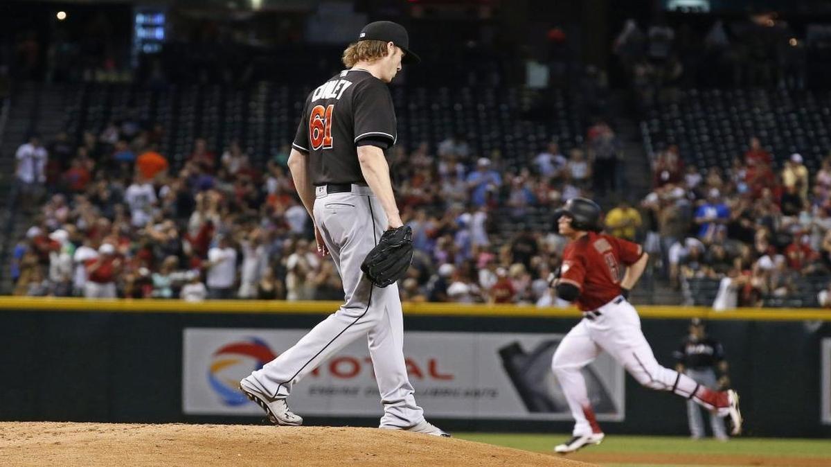 Miami Marlins pitcher Adam Conley (61) pauses on the mound as Arizona Diamondbacks' Peter O'Brien, right, rounds the bases after hitting a three-run home run during the first inning of a baseball game Sunday, June 12, 2016, in Phoenix.