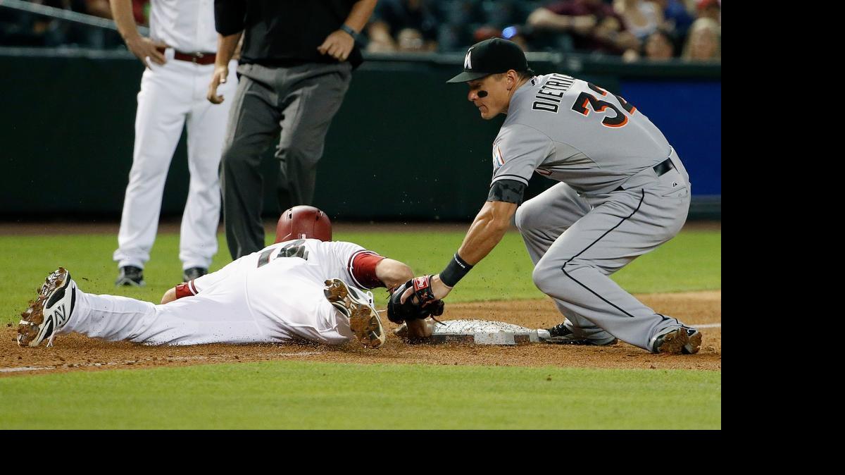 
Arizona Diamondbacks' Nick Ahmed, left, dives safely back to third base, beating the tag by Miami Marlins' Derek Dietrich (32) during the third inning of a baseball game, Monday, July 20, 2015, in Phoenix.

