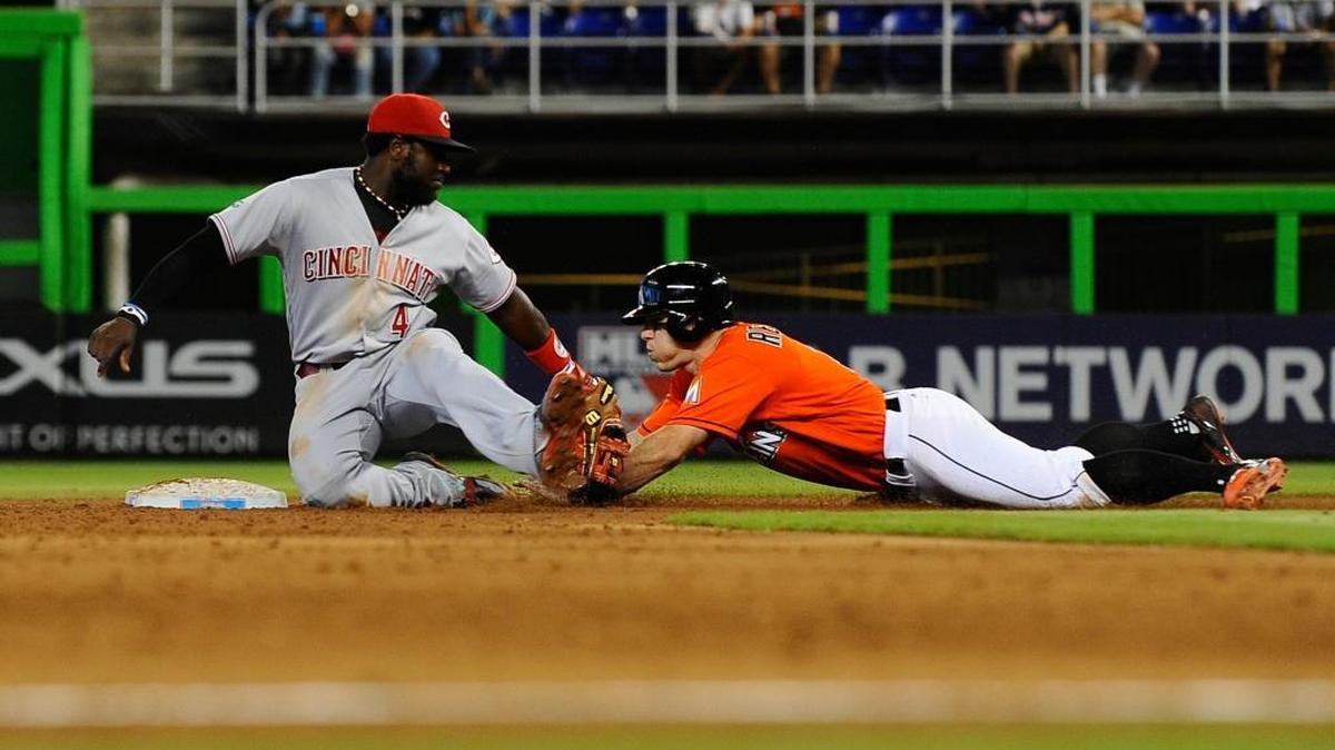 Miami Marlins catcher J.T. Realmuto (11) slides safely into second base past Cincinnati Reds second baseman Brandon Phillips (4) in the 6th inning during their game being held at Marlins Stadium on July 10, 2016.
