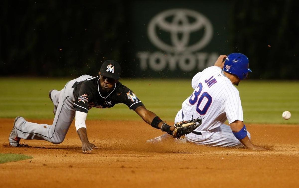 Chicago Cubs' Jon Jay (30) steals second after Miami Marlins second baseman Dee Gordon is unable to handle a throw from catcher J.T. Realmuto during the fifth inning of a baseball game Tues., June 6, 2017, in Chicago.