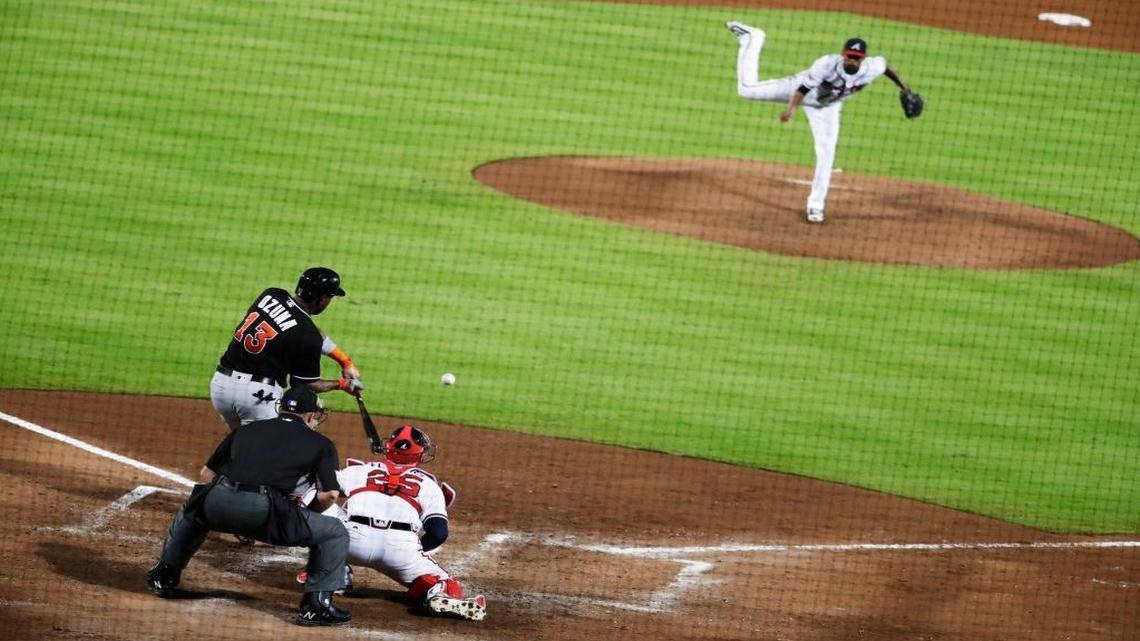 Miami Marlins' Marcell Ozuna swings to hit a three-run home run to score teammates Derek Dietrich and Martin Prado off Atlanta Braves starting pitcher Julio Teheran, top, in the sixth inning of a baseball game in Atlanta, Wed., Sept. 14, 2016.
