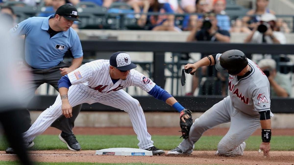 New York Mets third baseman Wilmer Flores, left, tags out Miami Marlins' Martin Prado at third base during the fourth inning of the baseball game at Citi Field, Mon., July 4, 2016 in New York. The Mets defeated the Marlins 8-6.