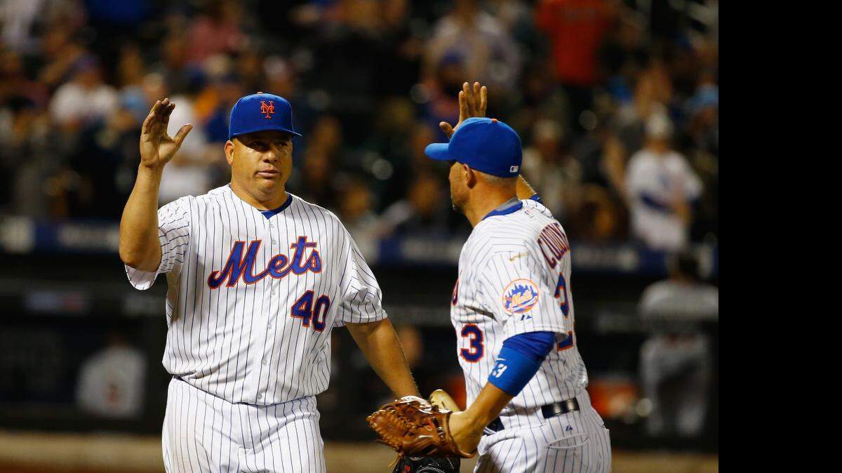 
Bartolo Colón of the New York Mets celebrates retiring the side with Michael Cuddyer, right, in the seventh inning against the Miami Marlins at Citi Field on April 17, 2015 in New York City.

