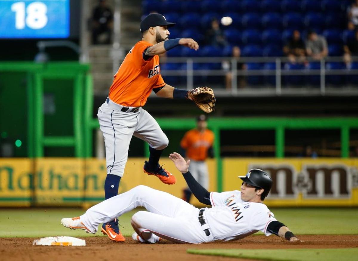 Houston Astros' Marwin Gonzalez throws to first in a failed attempt at a double play as Miami Marlins' Christian Yelich is out at second base during the first inning of a baseball game, Wed., May 17, 2017, in Miami.