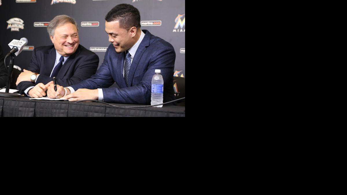 
Marlins slugger Giancarlo Stanton signs a 13-year, $325 million contract as owner Jeffrey Loria looks on at Marlins Park on Wednesday, Nov. 19, 2014. 
