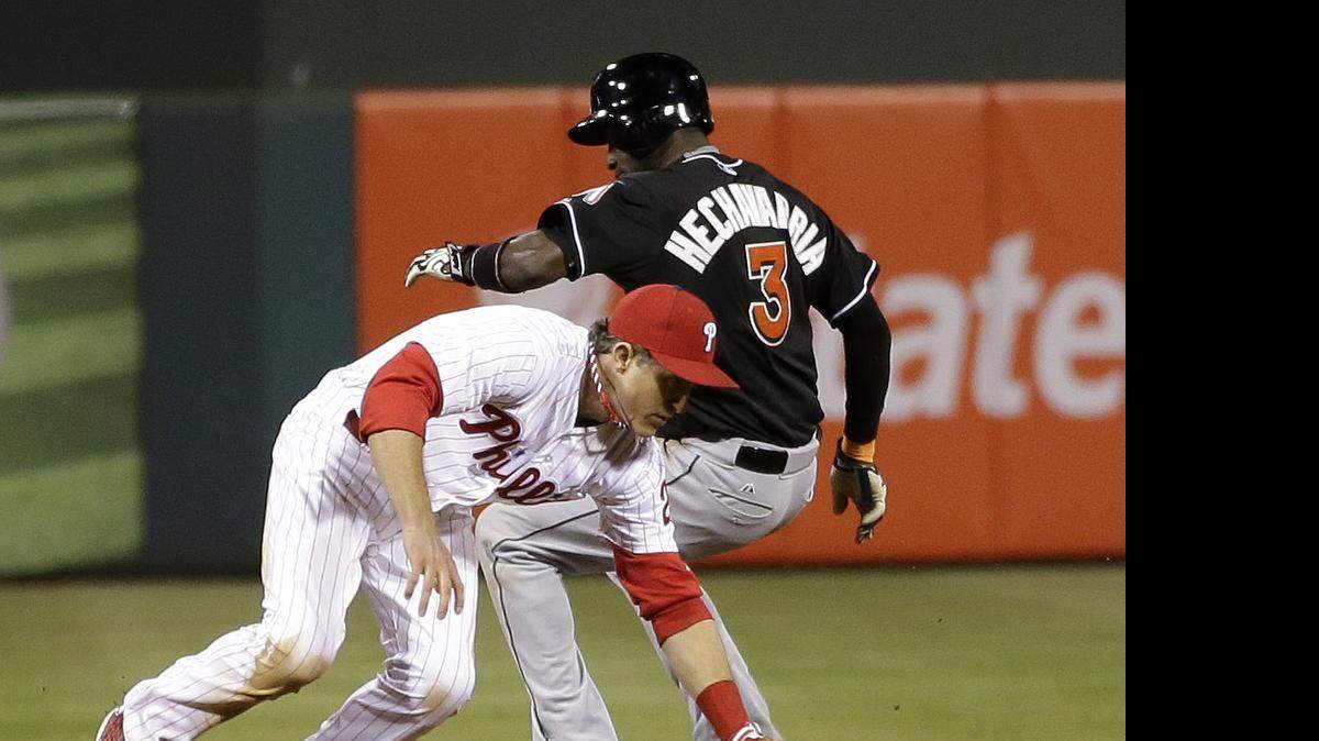 
Philadelphia Phillies second baseman Chase Utley, left, commits a fielding error on a hit by Miami Marlins' Jeff Baker as Adeiny Hechavarria, right, reaches second during the eighth inning Wednesday, April 22, 2015, in Philadelphia. Baker was safe at first on the error. Miami won 6-1.
