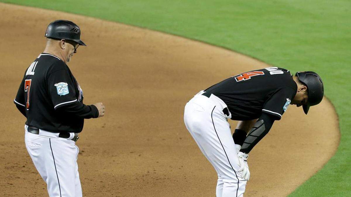 Marlins first base coach Perry Hill runs to check third baseman Martin Prado who got hurt after reaching to first base on error by Washington's short stop Trea Turner in the sixth inning of the Miami Marlins vs Washington Nationals game at Marlins Park, Friday, May 25, 2018.