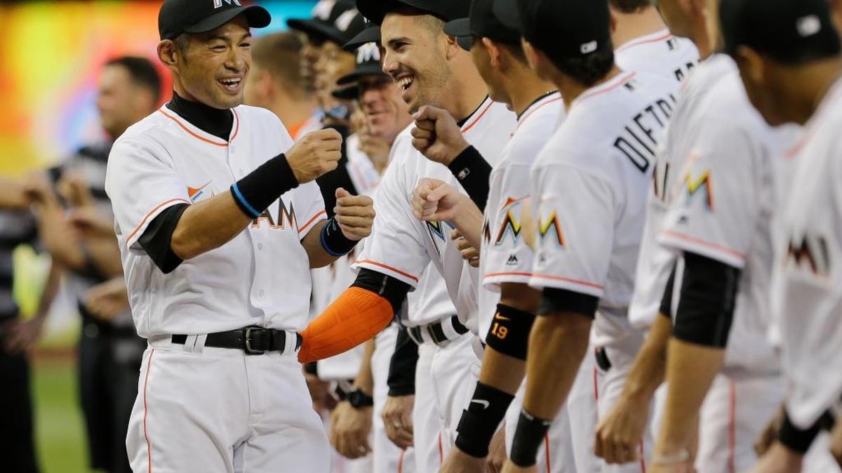 Miami Marlins outfielder Ichiro Suzuki, left, greets pitcher Jose Fernandez, right, and other teammates during a ceremony before Tuesday’s first game of the season against the Detroit Tigers.