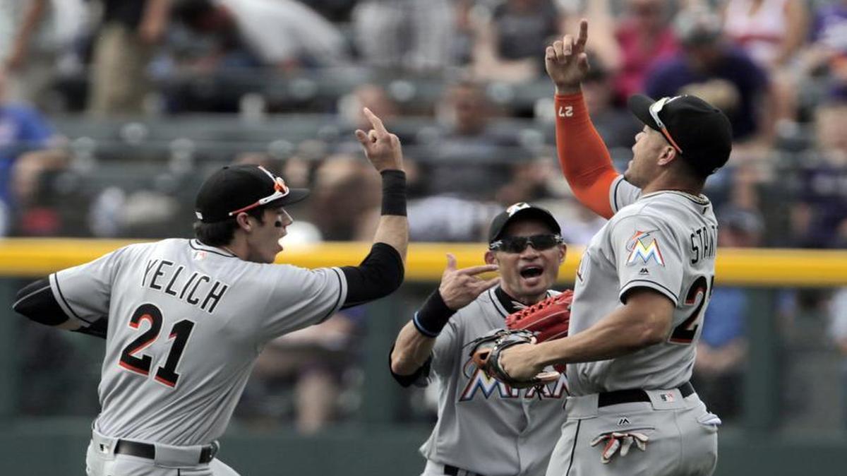 Miami Marlins center fielder Ichiro Suzuki (51) celebrates with Marlins left fielder Christian Yelich (21) and Marlins right fielder Giancarlo Stanton (27) after Miami's 10-7 victory over the Colorado Rockies in a baseball game in Denver on Sunday, Aug. 7, 2016. Suzuki's seventh inning triple was the 3,000th hit of his Major League Baseball career.
