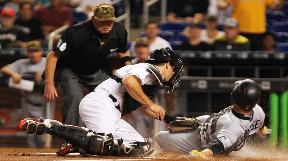Catcher J.T. Realmuto (11) of the Miami Marlins unsuccessfully tags out David Freese (23) of the Pittsburgh Pirates during the first inning of the first game of the series at Marlins Park on Mon., May 30, 2016.