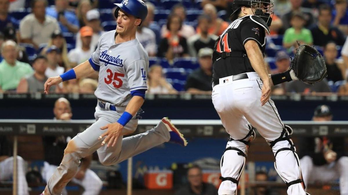 Los Angeles Dodgers first baseman Cody Bellinger (35) scores when second baseman Logan Forsythe (11) hit a sacrifice fly to right in the seventh inning as Miami Marlins catcher J.T. Realmuto (11) waits for the ball at home plate as the Miami Marlins play the Los Angeles Dodgers at Marlins Park on Saturday, July 15, 2017.