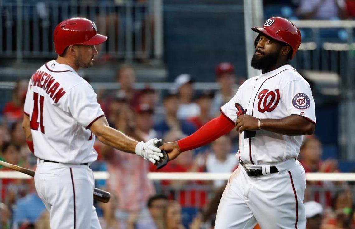 Washington Nationals Brian Goodwin (8) celebrates with teammate Ryan Zimmerman (11) after scoring off a single hit by teammate Bryce Harper during the third inning of baseball game against the Miami Marlins, Wed., Aug. 9, 2017, in Washington.