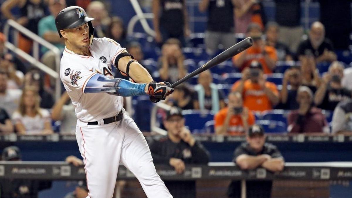 Miami Marlins right fielder Giancarlo Stanton (27) singles, first baseman Tyler Moore (28) scores, shortstop Miguel Rojas (19) advances to third and first baseman Tomas Telis (18) advances to second base in the seventh inning as the Marlins host the Atlanta Braves at Marlins Park on Friday, Sept. 29, 2017.