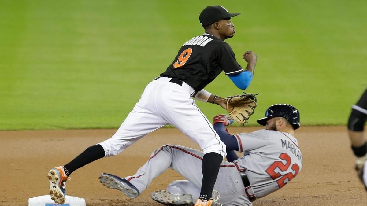 
Miami Marlins second baseman Dee Gordon (9) forces out Atlanta Braves' Nick Markakis (22) at second base and throws to first base to put out Hector Olivera to complete a double play in the first inning of a baseball game, Sunday, Sept. 27, 2015, in Miami. 
