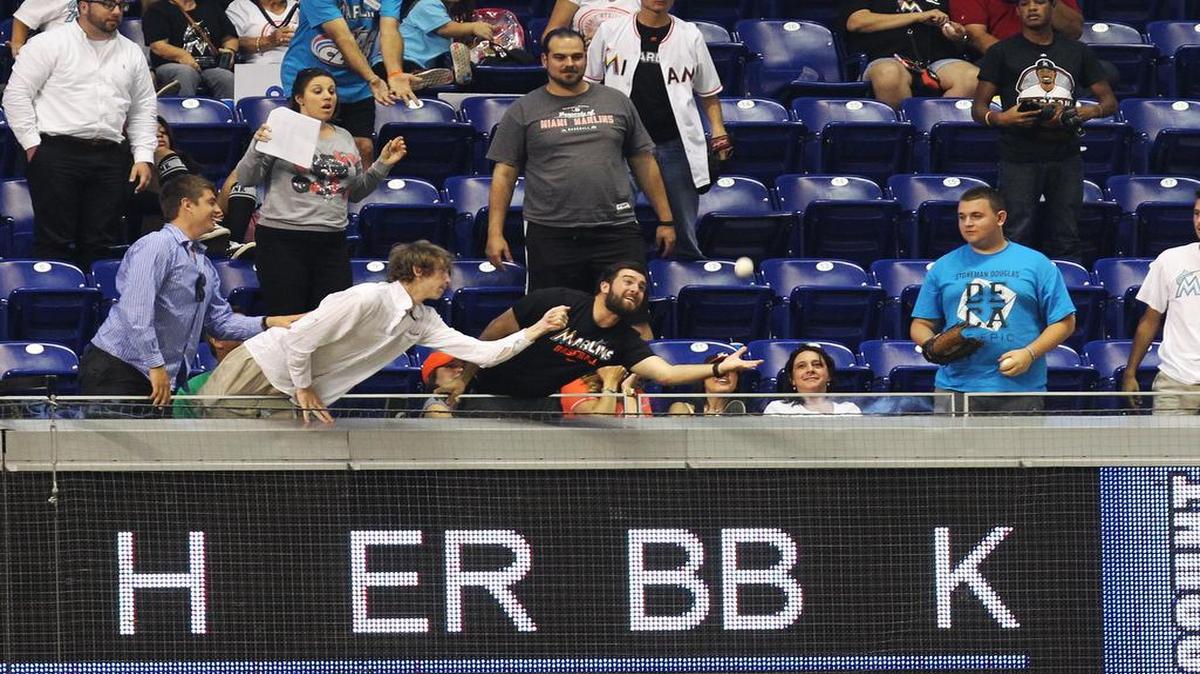 A Miami Marlins fan attempts to snach a ball hit for a home run during the last game of the series between the Miami Marlins and Colorado Rockies at Marlins Park on June 20, 2016.