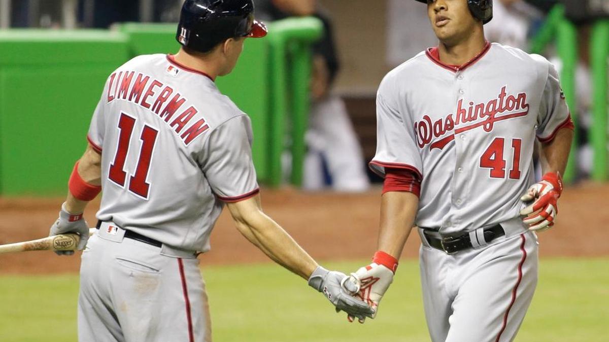 Washington Nationals’ Joe Ross (41) celebrates with Ryan Zimmerman (11) after he scored on an RBI double by Washington Nationals’ Bryce Harper during the third inning of a baseball game against the Miami Marlins, Wed., April 20, 2016, in Miami.