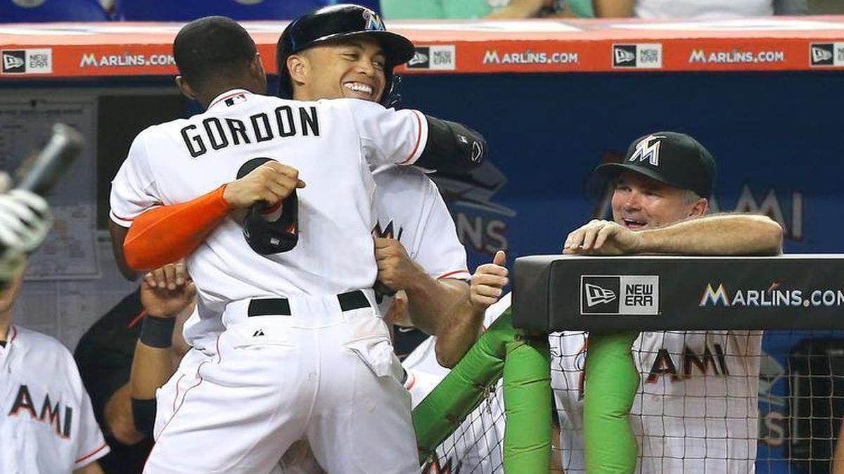 
Dee Gordon of the Miami Marlins is congratulated by teammate Giancarlo Stanton and manager Dan Jennings after scoring in the first inning against the New York Yankees on Tuesday, June 16, 2015 at Marlins Park in Miami.
