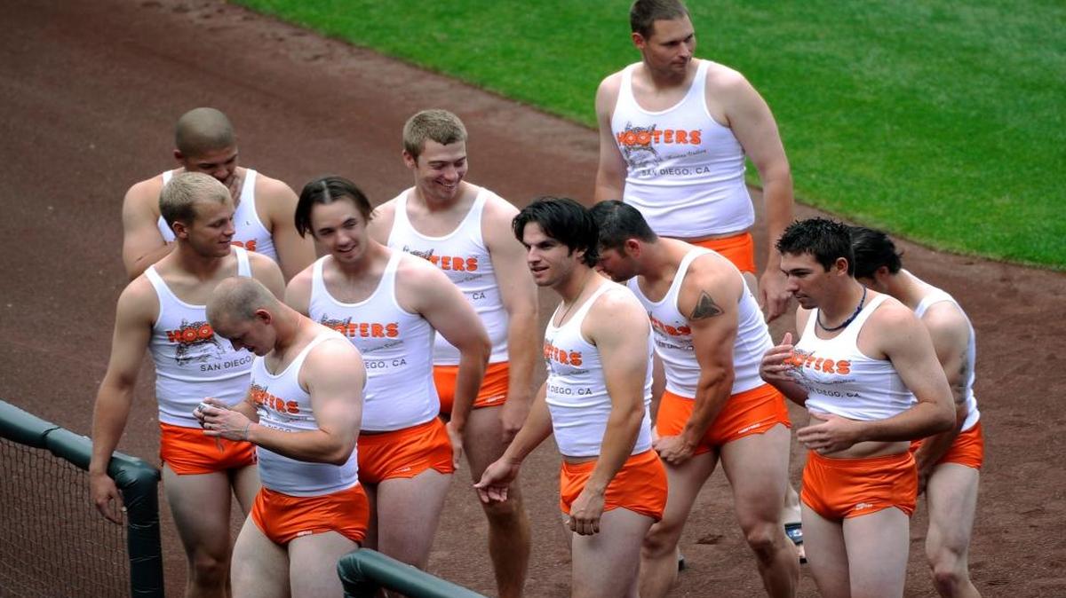 In this Sept. 17, 2008, file photo, rookie members of the San Diego Padres baseball team are dressed like waitpeople at a Hooter's restaurant, as part of rookie hazing after the Padres' 1-0 loss to the Colorado Rockies in a baseball game at Coors Field in Denver. That hazing ritual of dressing up rookies as Wonder Woman, Hooters Girls and Dallas Cowboys cheerleaders is now banned. Major League Baseball created an Anti-Hazing and Anti-Bullying Policy that covers the practice. As part of the sport's new labor deal, set to be ratified by both sides Tuesday, Dec. 12, 2016 the players' union agreed not to contest it.