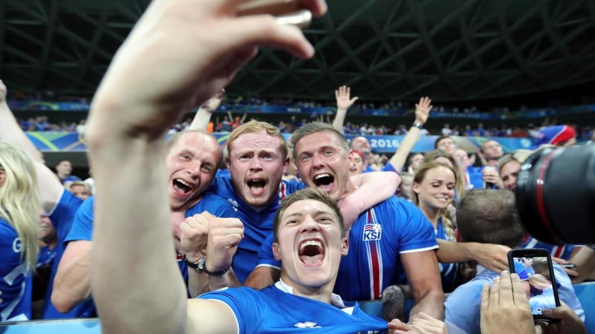 Iceland's Haukur Heidar Hauksson takes a selfie with supporters at the end of the Euro 2016 round of 16 soccer match between England and Iceland, at the Allianz Riviera stadium in Nice, France, Mon., June 27, 2016.