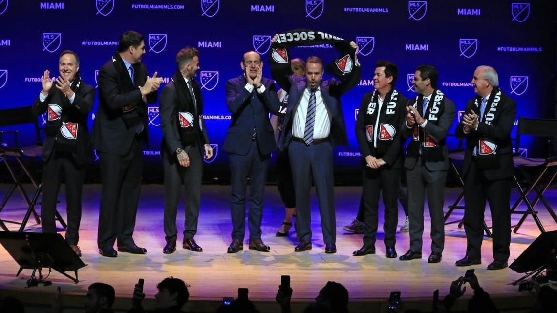 Partner Jose Mas raises an MLS soccer scarf as the arrival of Miami soccer is announced at the Adrienne Arsht Center in Miami on Monday, Jan. 29, 2018.