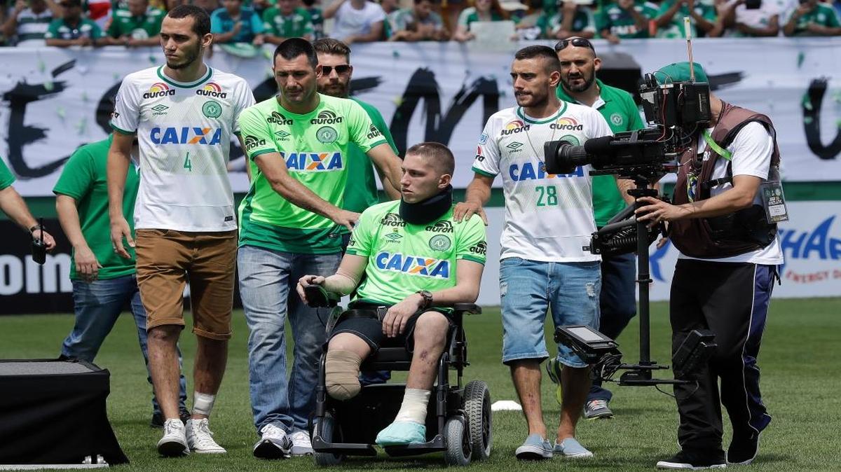 Chapecoense players Neto, left, goalkeeper Follmann, on the wheelchair, and Alan Ruschel, right, the three players that survived the air crash, arrive for an Sudamericana trophy award ceremony prior to a friendly match against Palmeiras, in Chapeco, Brazil, Saturday, Jan. 21, 2017. Almost two months after the air tragedy that killed 71 people, including 19 team players, Chapecoense plays at its Arena Conda stadium against the 2016 Brazilian champion Palmeiras.