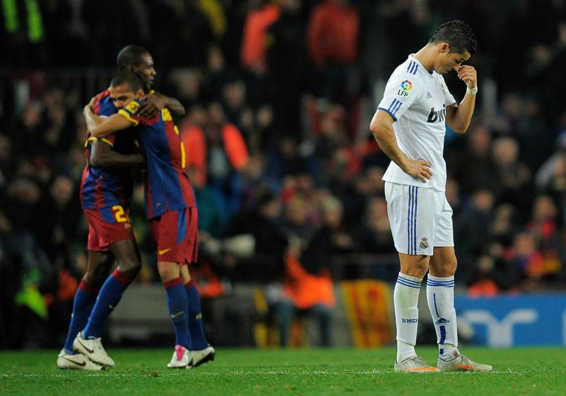 Cristiano Ronaldo of Real Madrid (R) looks down as Eric Abidal and Dani Alves of Barcelona celebrates the fifth goal against Real Madrid during the La Liga match between Barcelona and Real Madrid at the Camp Nou Stadium on Nov. 29, 2010 in Barcelona, Spain. Bacelona won 5-0.