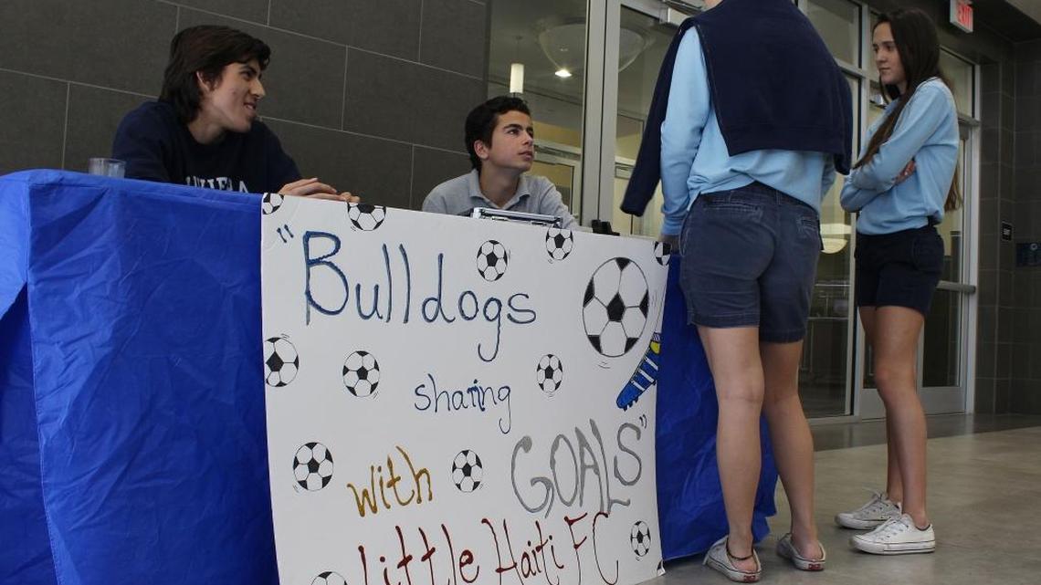 Max De Witte, 17, left, and Stefano Marconi, 16, right, sell Dairy Queen ice cream sandwiches during lunch hour on Friday, Dec. 16 at the Riviera Preparatory School to raise money for new equipment they plan to donate to the Little Haiti Football Club.