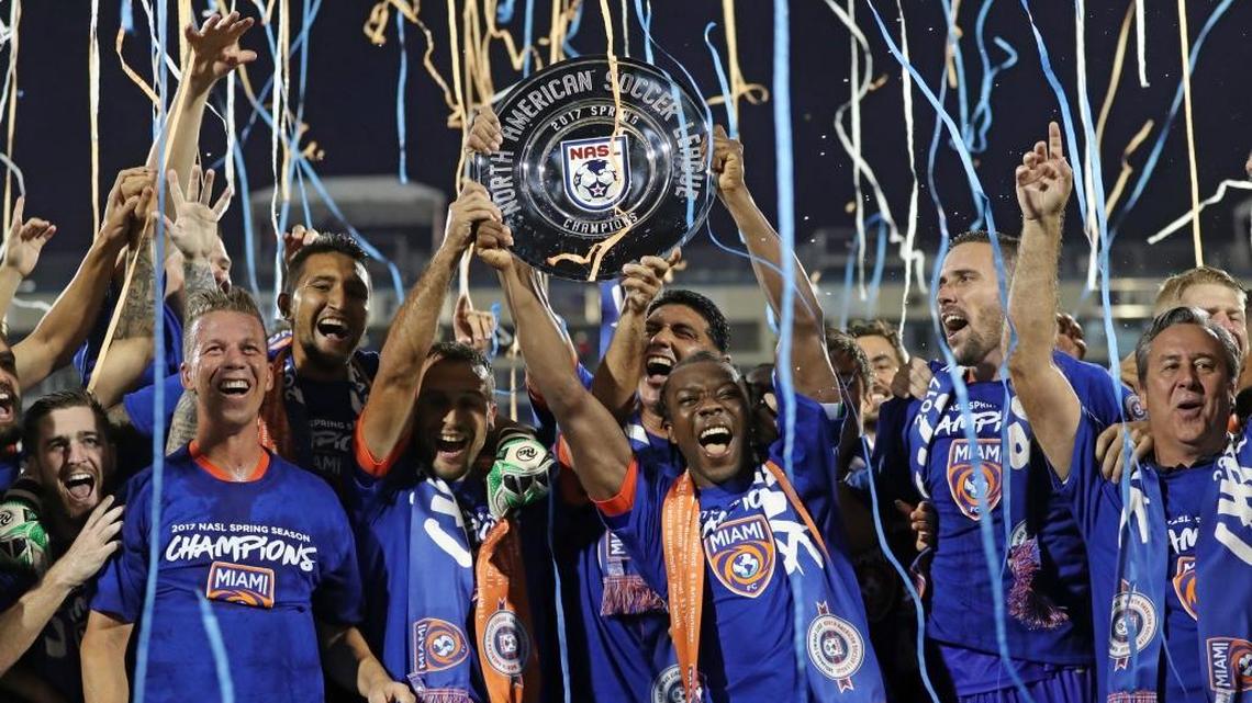Miami FC midfielder Michael Lahoud (26) lifts the championship trophy as teammates celebrates after Miami FC defeats San Francisco Delta in Riccardo Silva Stadium at FIU on Saturday, July 8, 2017.