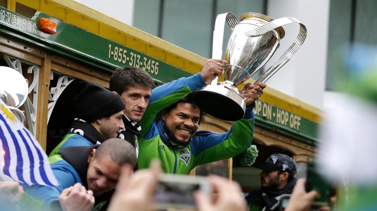 The Sounders’ Roman Torres, now with Inter Miami, holds the 2017 MLS Cup trophy during a victory rally in Seattle. Seattle beat Toronto FC 5-4 in a penalty-kick shootout to win its first championship.