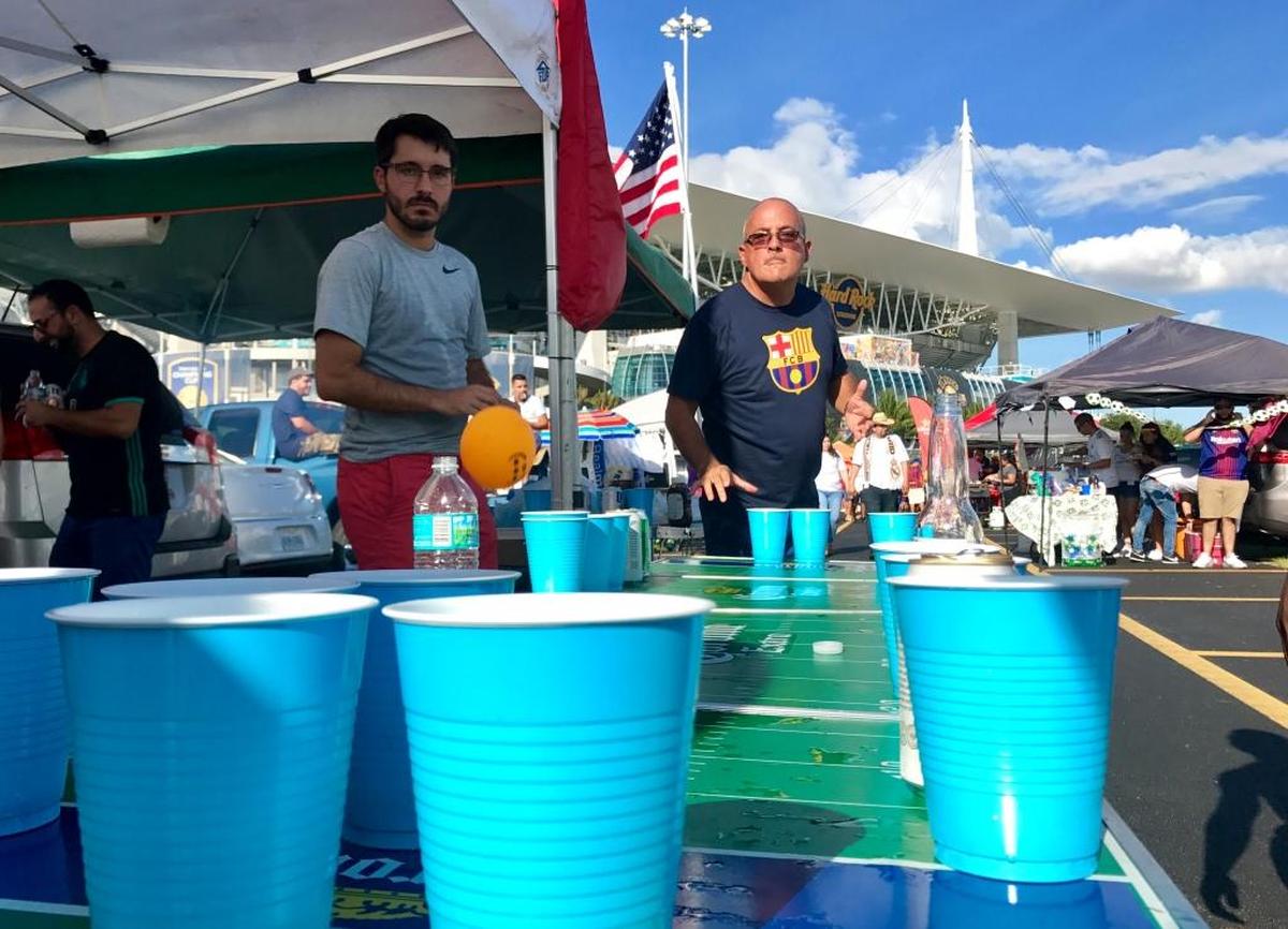 Luis Alberto Gomez watches intently the second before his ping pong ball splashes into a cup full of beer outside Hard Rock Stadium before El Clásico. Hundreds of tailgaters partied in sweltering temperatures before the match.