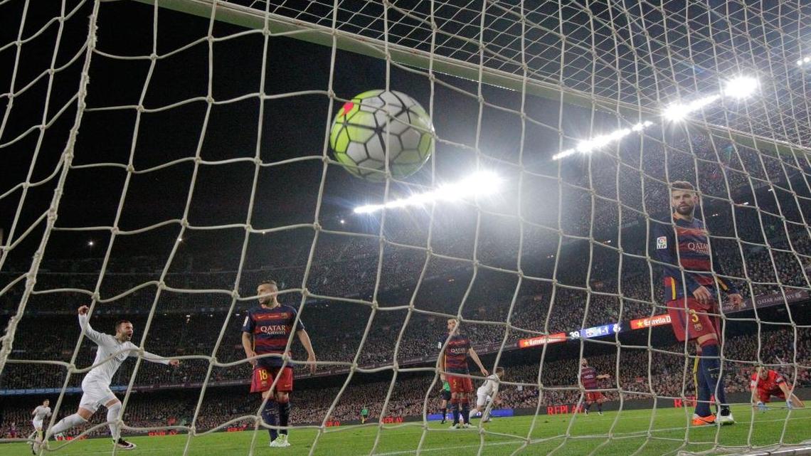 Barcelona goalkeeper Claudio Bravo, right, and Gerard Pique, 2nd right, watch the ball hit the net after Real Madrid's Cristiano Ronaldo scored the winning goal during a Spanish La Liga soccer match between Barcelona and Real Madrid, dubbed 'el clasico', at the Camp Nou stadium in Barcelona, Spain, Sat., April 2, 2016. Real Madrid won 2-1.