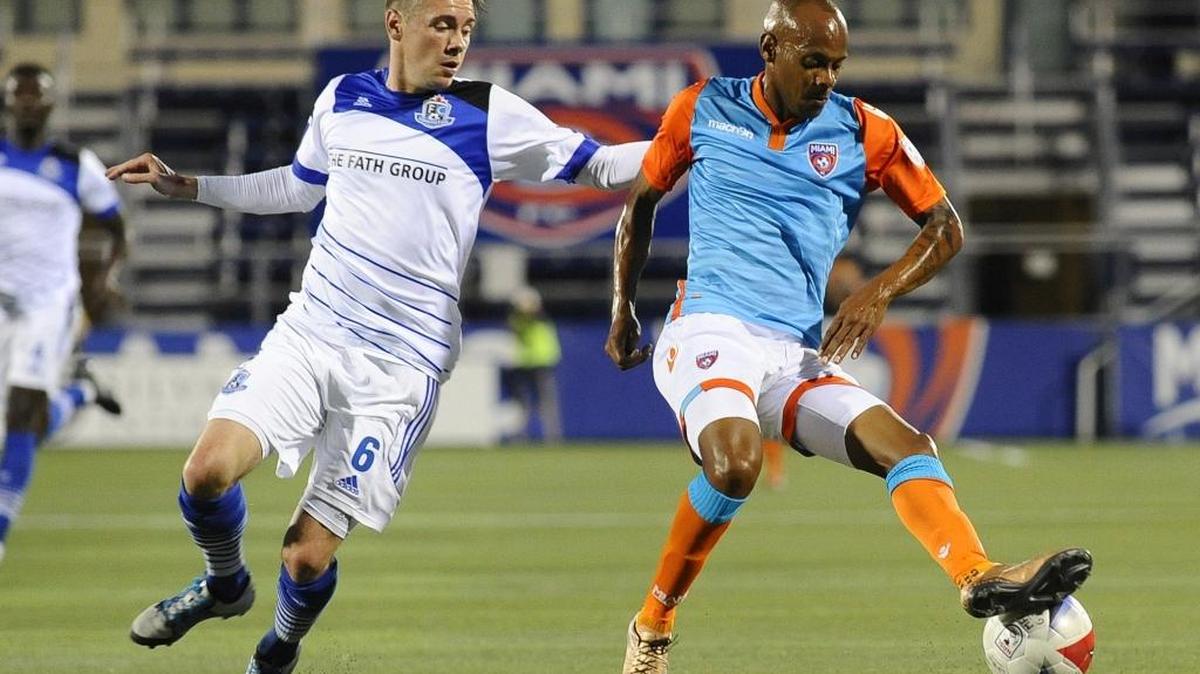 Miami FC midfielder Ariel Martinez, right, tries to get past FC Edmonton’s Nik Ledgerwood during Saturday night’s game at FIU Stadium. Martinez scored Miami FC’s only goal in the game to deliver the expansion franchise’s first victory.