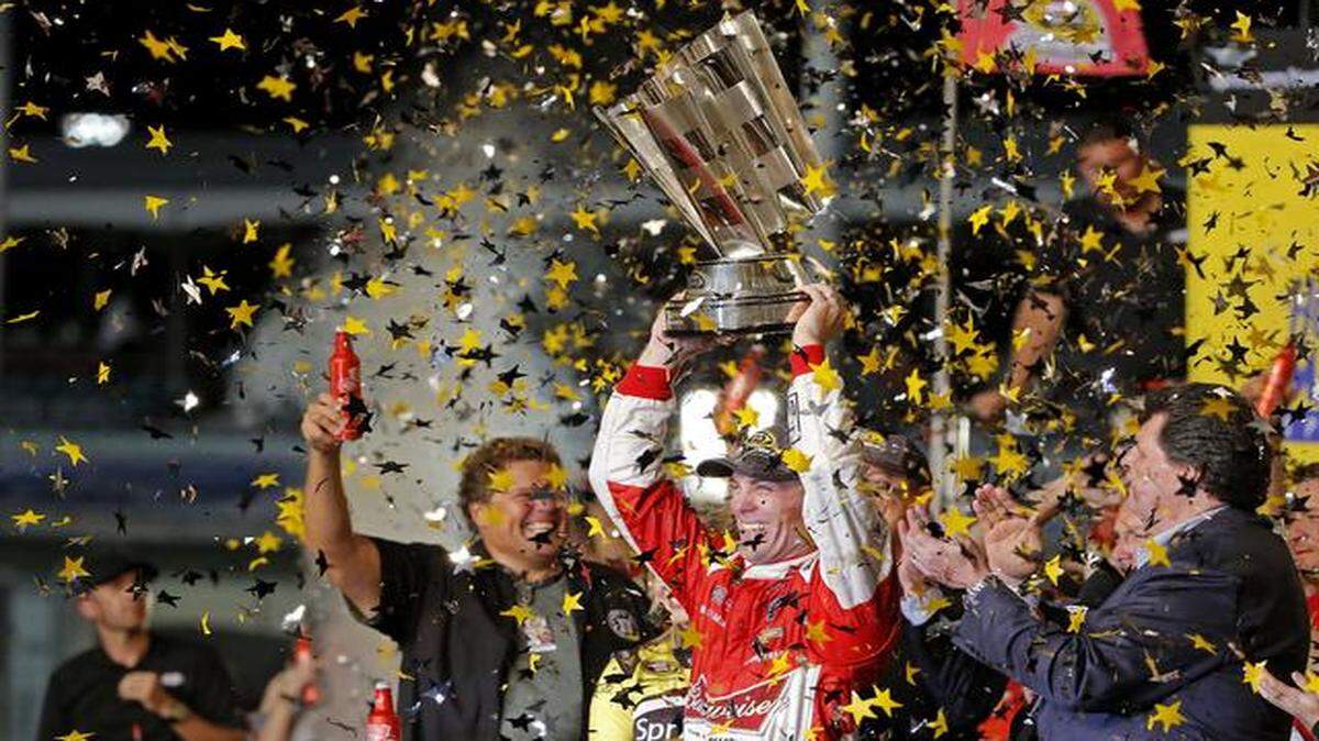 
Sprint Cup Series driver Kevin Harvick holds up the trophy after winning the Sprint Cup Series and the Ford EcoBoost 400 at Homestead-Miami Speedway in Homestead on Nov. 16, 2014.
