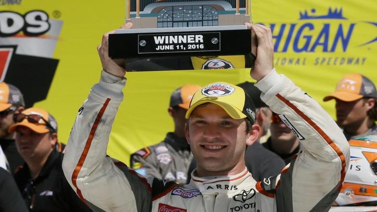 Daniel Suarez holds the winners trophy after winning the NASCAR Xfinity series auto race at Michigan International Speedway, Saturday, June 11, 2016 in Brooklyn, Mich. The was the first Xfinity win for Suarez.