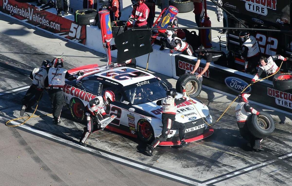 Race leader Ryan Blaney makes a pit stop for tires and fuel during the NASCAR Xfinity Series auto race at Phoenix International Raceway, Sat., Nov. 11, 2017, in Avondale, Ariz. Shannon Myers, a former wide receiver who has the distinction of being the final draft pick of Don Shula’s legendary career, is a rear tire changer for Blaney.