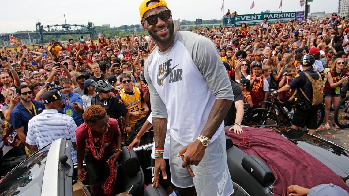 LeBron James stands in the back of a Rolls Royce at the beginning of the NBA championship parade in downtown Cleveland on June 22.